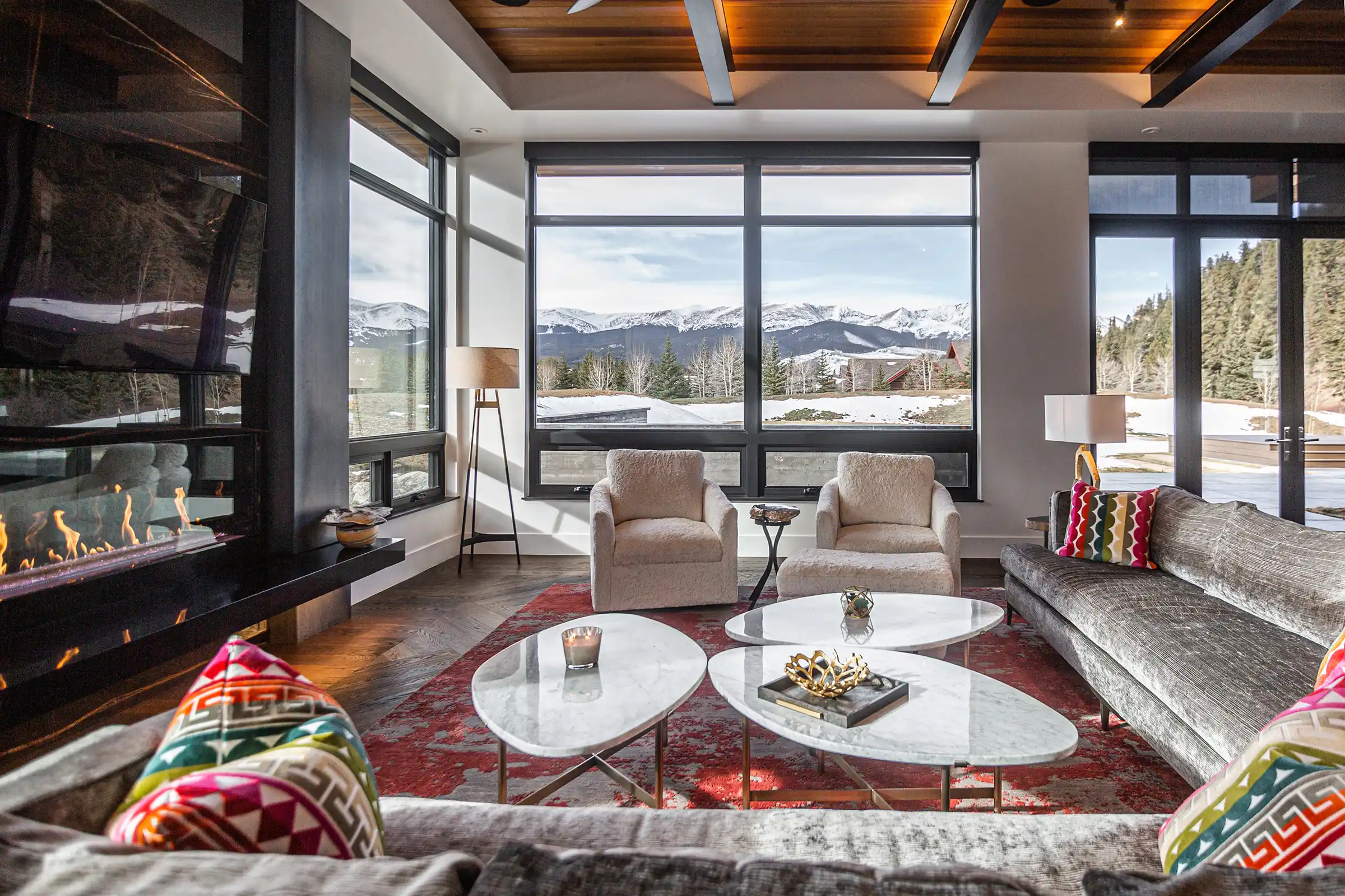 Living room with a linear fireplace and mountain views in a Colorado home